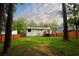 Back exterior view of home with a wooden deck and fenced-in yard with mature trees at 5023 Rockborough Trl, Norcross, GA 30071