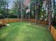 Picturesque backyard featuring a large lawn area, surrounded by a privacy fence and mature trees at 5023 Rockborough Trl, Norcross, GA 30071