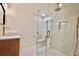 Sleek bathroom with glass shower, toilet, sink with wooden vanity and gold fixtures at 5023 Rockborough Trl, Norcross, GA 30071