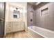 This bathroom features a tub with shower, tiled walls, recessed niche, and white vanity with lots of storage at 5023 Rockborough Trl, Norcross, GA 30071
