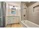 Bathroom featuring a tub and shower, white cabinets, quartz countertop, and stylish fixtures at 5023 Rockborough Trl, Norcross, GA 30071