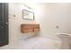 Bathroom with geometric tile flooring, floating vanity, toilet, and light fixture above the black framed mirror at 5023 Rockborough Trl, Norcross, GA 30071