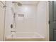 Corner bathtub with tiled shower featuring a shower head, handheld wand, and a recessed niche at 5023 Rockborough Trl, Norcross, GA 30071