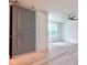 Bedroom featuring a sliding barn door, ceiling fan, and large window at 5023 Rockborough Trl, Norcross, GA 30071