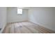 This bedroom features light, wood-look floors, neutral paint, and a window that provides natural light at 5023 Rockborough Trl, Norcross, GA 30071
