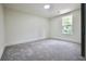 Empty bedroom with neutral colored walls and carpeting, plus a window that allows natural light to enter at 5023 Rockborough Trl, Norcross, GA 30071