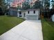 Front exterior of house featuring a large driveway and two-car garage in a lush green yard at 5023 Rockborough Trl, Norcross, GA 30071