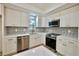 Modern kitchen with white cabinets, stainless steel appliances, and a stylish backsplash at 5023 Rockborough Trl, Norcross, GA 30071