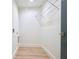 A small, empty laundry room with vinyl plank flooring and a wire rack above the washer/dryer hookups at 5023 Rockborough Trl, Norcross, GA 30071