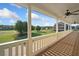 Spacious porch with ceiling fans and a scenic view of the green neighborhood and the sunny sky at 92 River Walk Pkwy, Euharlee, GA 30145