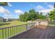 Large wooden porch with a railing that overlooks a wide green lawn and blue sky at 92 River Walk Pkwy, Euharlee, GA 30145