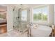 Bathroom featuring a large tub, a glass shower enclosure and an open view to the Primary bedroom at 92 River Walk Pkwy, Euharlee, GA 30145