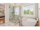 A luxurious bathroom featuring separate shower and tub with backyard views at 92 River Walk Pkwy, Euharlee, GA 30145