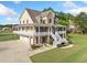 Captivating home boasting a three-car garage, lush landscaping, and a charming wraparound porch for ultimate curb appeal at 92 River Walk Pkwy, Euharlee, GA 30145