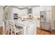 Modern white kitchen with stainless steel appliances, granite countertops, and hardwood floors at 92 River Walk Pkwy, Euharlee, GA 30145