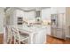 Beautiful kitchen boasts white cabinets, stainless steel appliances, and a granite island with seating at 92 River Walk Pkwy, Euharlee, GA 30145