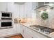 Kitchen featuring white cabinets, stainless steel oven, range hood, and a decorative backsplash at 92 River Walk Pkwy, Euharlee, GA 30145