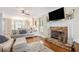 Bright living room with a stone fireplace, hardwood floors, and large windows that let in natural light at 92 River Walk Pkwy, Euharlee, GA 30145