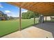 Covered patio area with concrete flooring overlooks the lush green backyard and a clear sky at 92 River Walk Pkwy, Euharlee, GA 30145