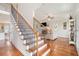 Elegant staircase with hardwood steps and iron railings, leading to an open-concept living area with fireplace at 92 River Walk Pkwy, Euharlee, GA 30145