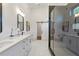 Modern main bathroom with dual vanity, black fixtures, tiled shower with glass door, and white floors at 1464 Ezra Church Nw Dr, Atlanta, GA 30314