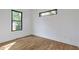 An empty bedroom with light hardwood floors and multiple black trimmed windows at 1464 Ezra Church Nw Dr, Atlanta, GA 30314