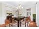 Dining room features hardwood floors, wainscoting, and a stylish chandelier over a dark wood table at 2330 Cheatham Creek Ct, Cumming, GA 30040