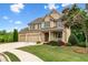 Charming two-story brick home with a three-car garage, a covered front porch and a large front yard at 2330 Cheatham Creek Ct, Cumming, GA 30040