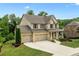 Charming two-story brick home with a three-car garage, a covered front porch and a large front yard at 2330 Cheatham Creek Ct, Cumming, GA 30040