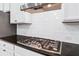 This kitchen features a gas stovetop, granite countertop, white cabinetry and white subway tile backsplash at 2330 Cheatham Creek Ct, Cumming, GA 30040