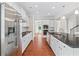A stainless steel refrigerator stands next to granite counters, subway tile and white cabinets at 2330 Cheatham Creek Ct, Cumming, GA 30040