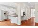Bright open kitchen showcasing stainless steel appliances, granite countertops, white cabinetry, and hardwood flooring at 2330 Cheatham Creek Ct, Cumming, GA 30040