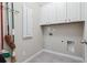 Functional laundry room with white cabinets and tiled flooring for easy maintenance at 2330 Cheatham Creek Ct, Cumming, GA 30040