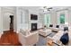 Staged living room featuring a fireplace, custom built-ins, hardwood floors, and neutral-toned furniture at 2330 Cheatham Creek Ct, Cumming, GA 30040