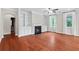 Living room with a fireplace, custom built-ins, hardwood floors, and a large window providing natural light at 2330 Cheatham Creek Ct, Cumming, GA 30040