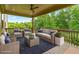Covered outdoor living area featuring comfortable seating, stylish decor, and scenic views of surrounding trees at 2330 Cheatham Creek Ct, Cumming, GA 30040