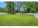 Expansive fenced backyard featuring lush green grass and mature trees, providing privacy and ample space for outdoor activities at 25 Carriage Ct, Stockbridge, GA 30281