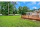 Spacious backyard with grass, a wood deck, and mature trees at 25 Carriage Ct, Stockbridge, GA 30281