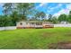 View of the backyard with a deck, fenced yard, lush green grass and a charming exterior of the house at 25 Carriage Ct, Stockbridge, GA 30281