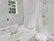 Simple and functional bathroom with a white sink, toilet, walk-in shower, and natural light from the window at 25 Carriage Ct, Stockbridge, GA 30281