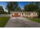 Charming one-story home with red accents, an attached garage, mature trees and a spacious concrete driveway at 25 Carriage Ct, Stockbridge, GA 30281