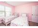 Pink bedroom featuring two twin beds with floral bedding and a door with decorative appliques at 4560 Buckskin Way, Douglasville, GA 30135