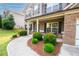 Inviting covered porch with neatly trimmed shrubs and a walkway leading to the front door at 4560 Buckskin Way, Douglasville, GA 30135