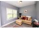 Cozy sitting room with a comfortable sofa, ottoman, and ample natural light, ideal for relaxing at 4560 Buckskin Way, Douglasville, GA 30135