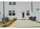 A relaxing patio area with seating and back door access to a home with neutral siding at 94 Depot Landing Rd, Auburn, GA 30011