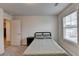 Bright bedroom features soft carpeting, a twin bed, nightstand, and a window with natural light at 94 Depot Landing Rd, Auburn, GA 30011