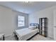 This bedroom features a twin bed, modern bookshelf, neutral color palette, and a window at 94 Depot Landing Rd, Auburn, GA 30011