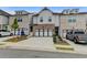 Inviting townhome showcasing a two-car garage, classic brickwork, and professional landscaping at 94 Depot Landing Rd, Auburn, GA 30011