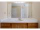 Bathroom featuring a single sink vanity with oak cabinets and a large, frameless mirror at 120 Paces Lakes Pt, Dallas, GA 30157
