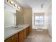 Bathroom featuring a tub, large mirror, vanity with cabinets, and a window for natural light at 120 Paces Lakes Pt, Dallas, GA 30157